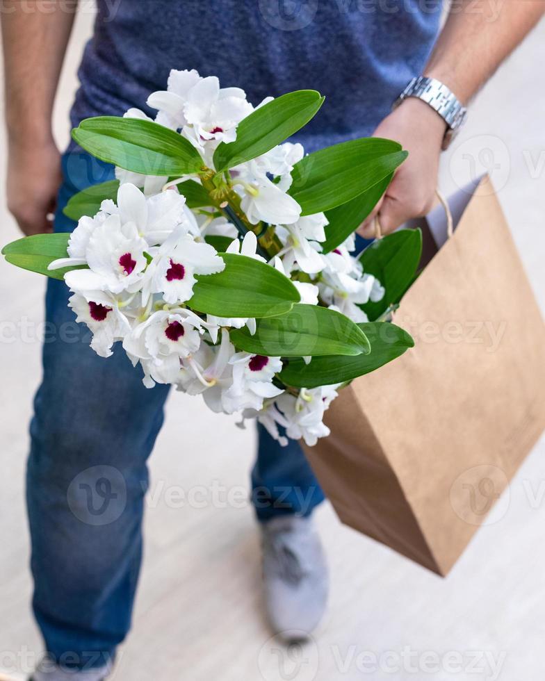 flor de orquídea dendrobium nobile branca em sacola de compras foto