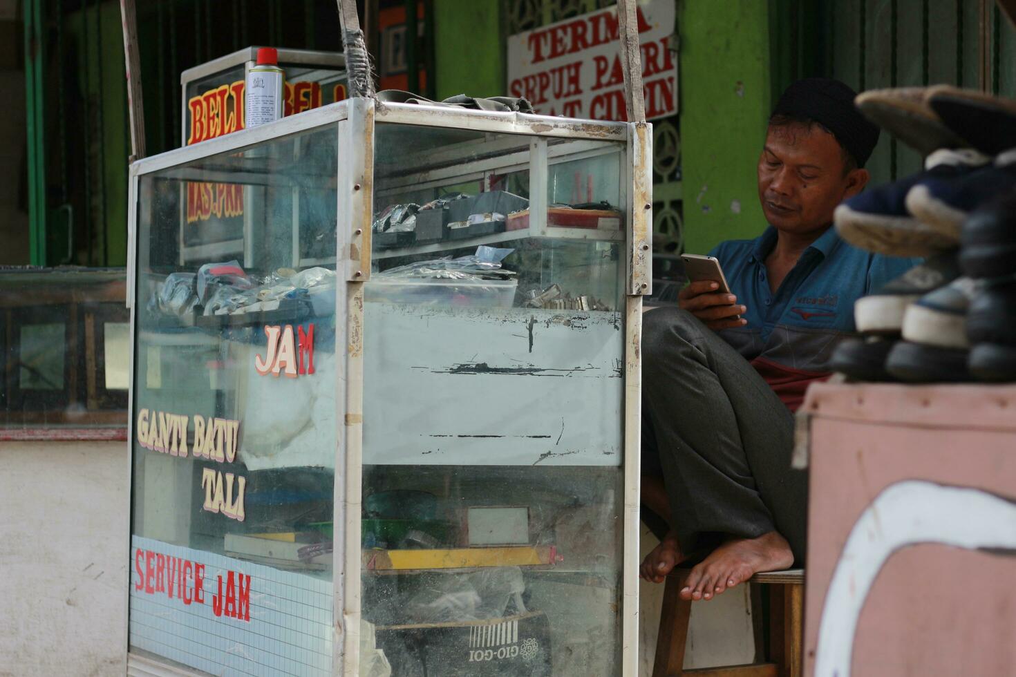bogor, Indonésia - 2022. uma Assistir reparador estava esperando para uma cliente às dele pequeno ficar de pé de a na estrada. uma único profissão a partir de Indonésia. foto