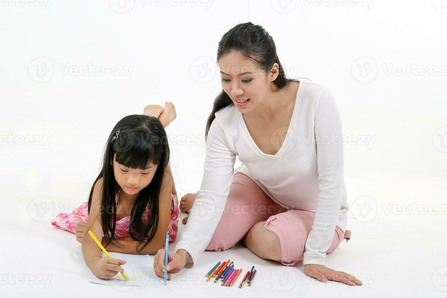 sul leste ásia mãe filha criança estude ler escrever conversa em chão branco fundo lápis papel foto