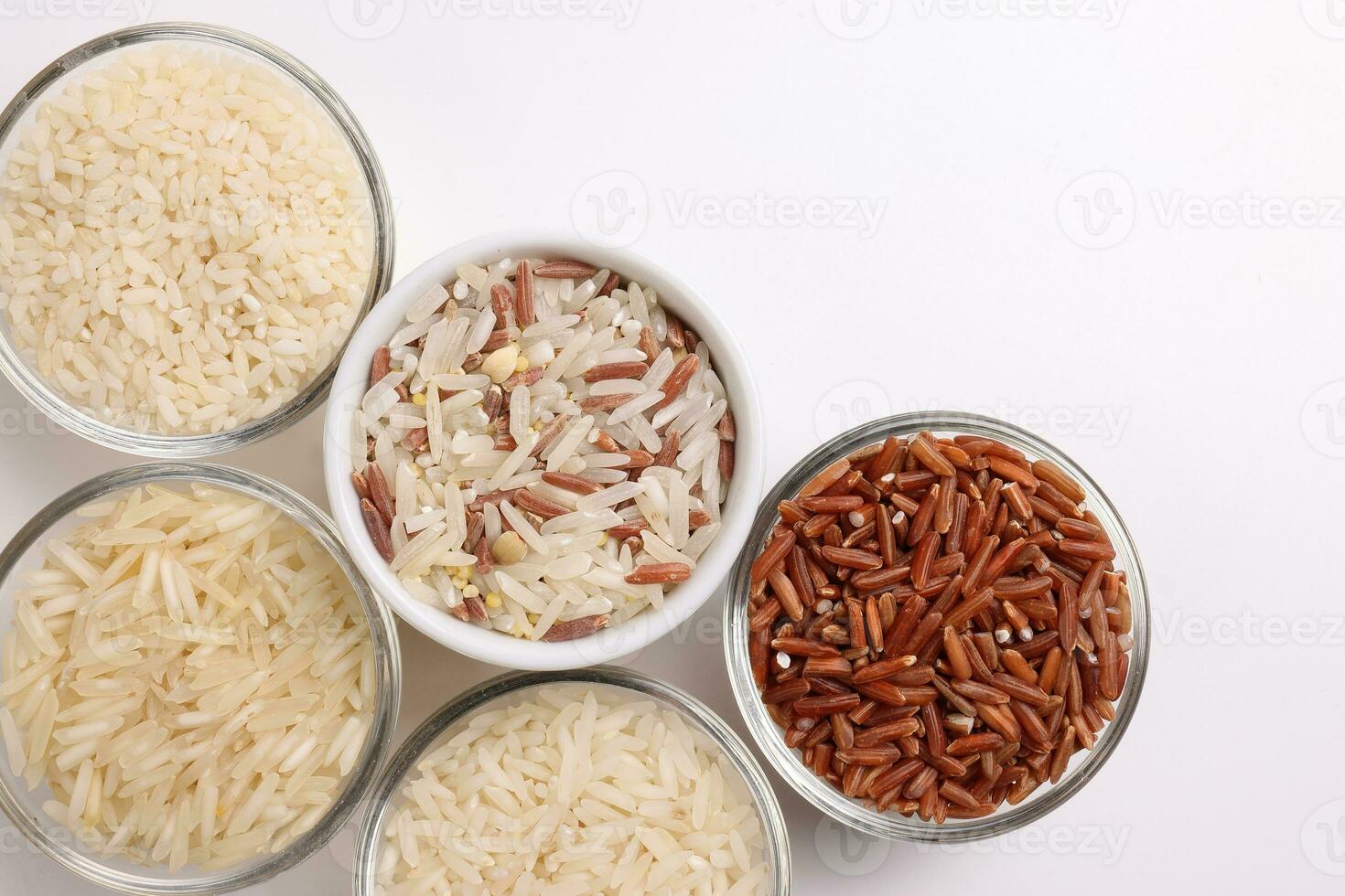 grandes grão basmati médio grão jasmim curto grão Arroz a grega polau risoto Castanho baixo glicêmico índice gi arroz dentro pequeno vidro tigela em branco fundo cópia de texto espaço topo plano deitar Visão foto