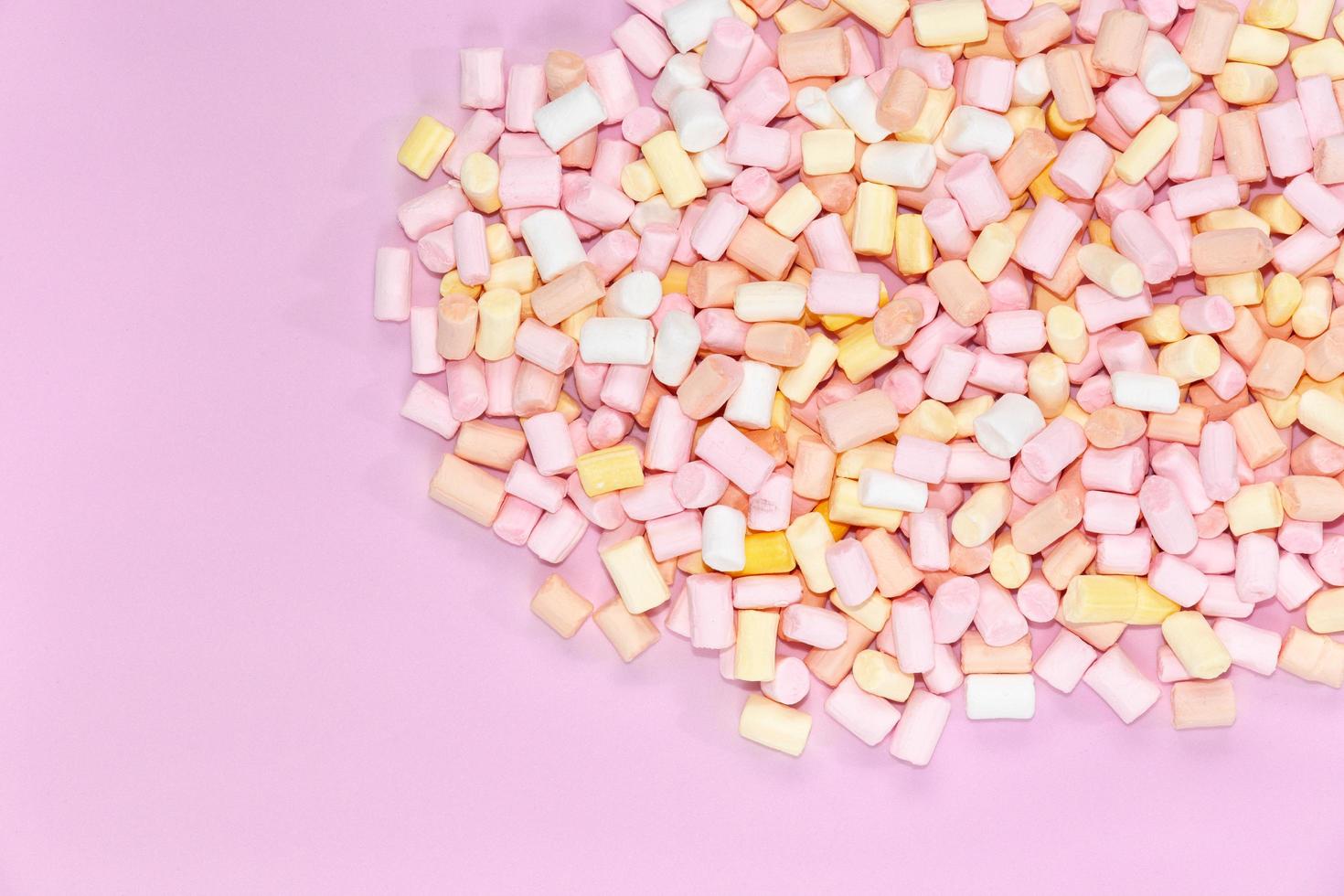 marshmallows multicoloridos em um fundo rosa monocromático foto