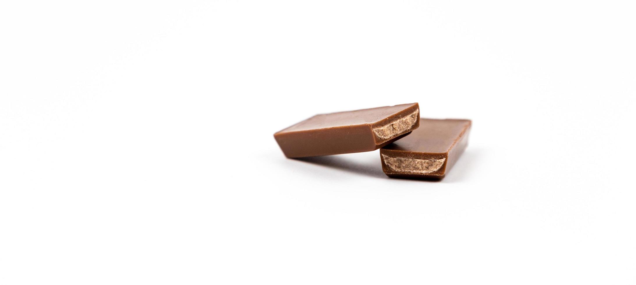 pedaços de barra de chocolate sobre fundo branco foto