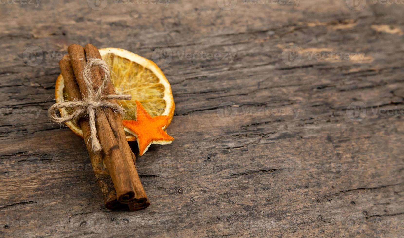 uma pilha de paus de canela e laranja seca foto