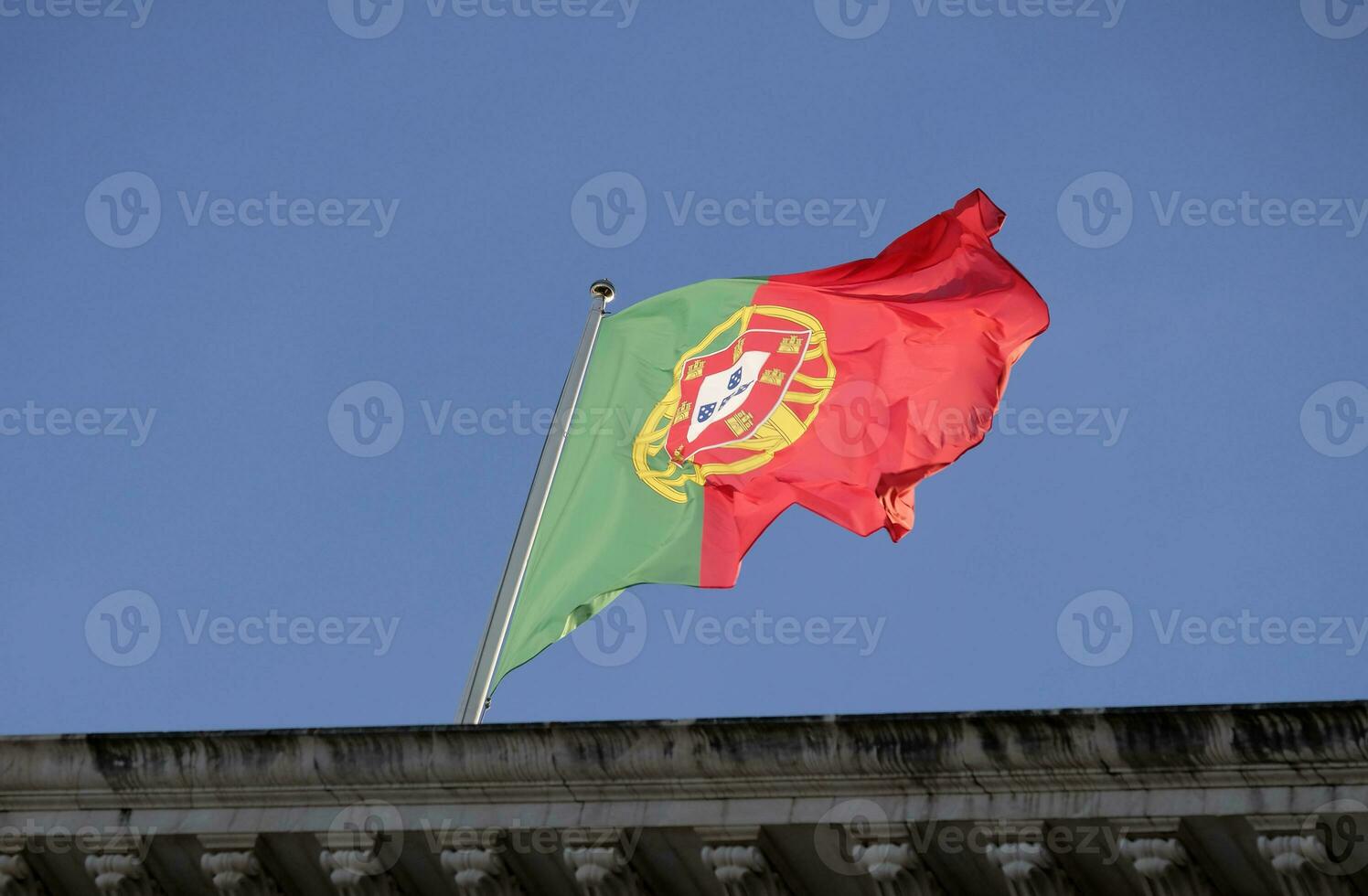 Português bandeira acenando dentro a vento contra uma Claro céu foto