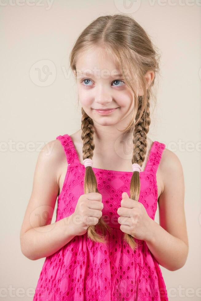 criança menina segurando tranças e sorridente foto