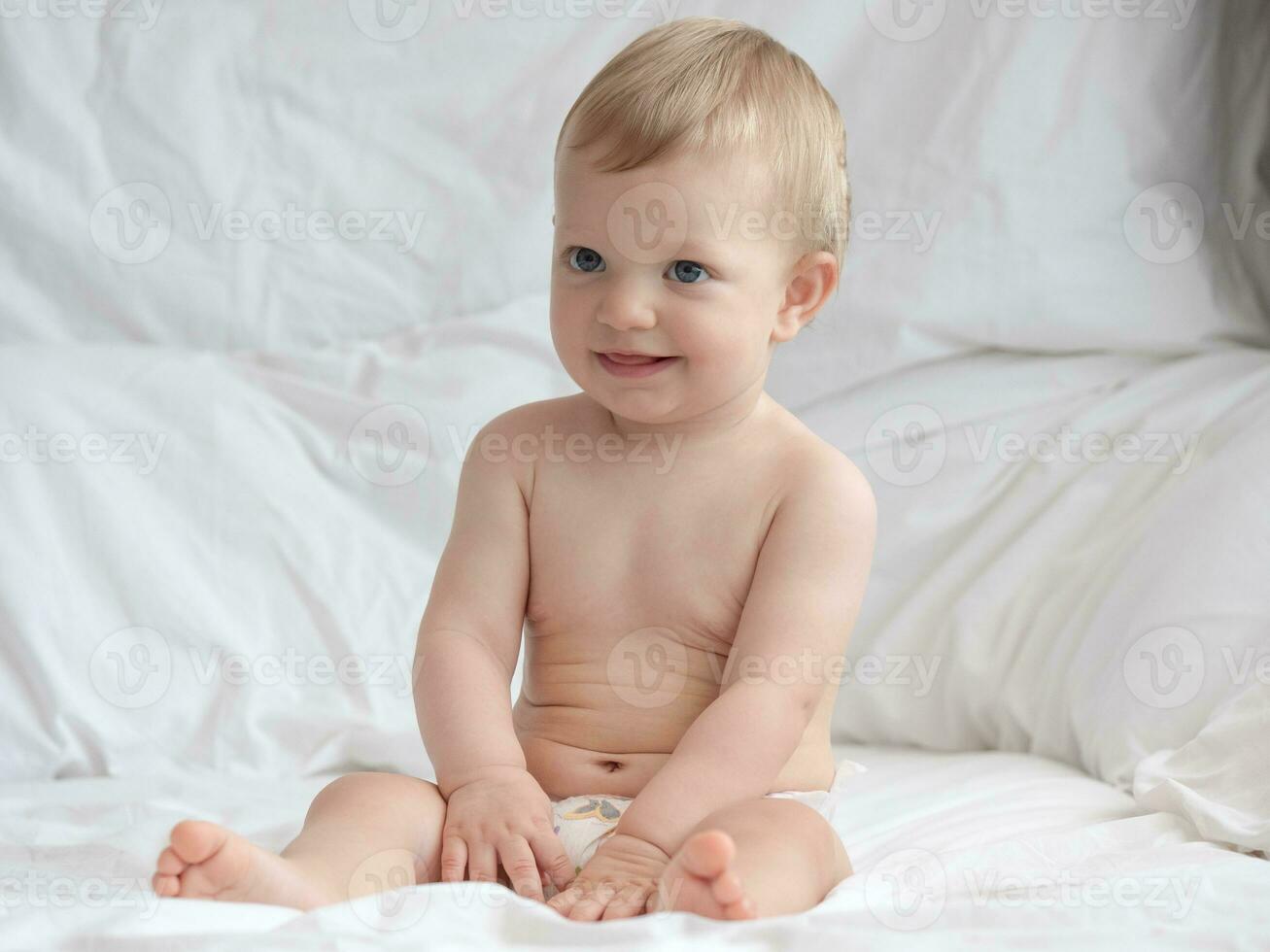 fofa bebê sentado e sorridente em a cama foto