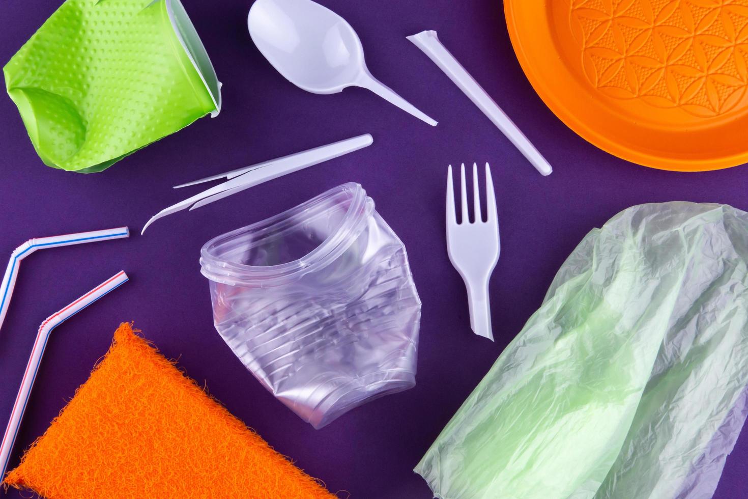 embalagem de produtos de plástico laranja, branco e verde em fundo roxo foto