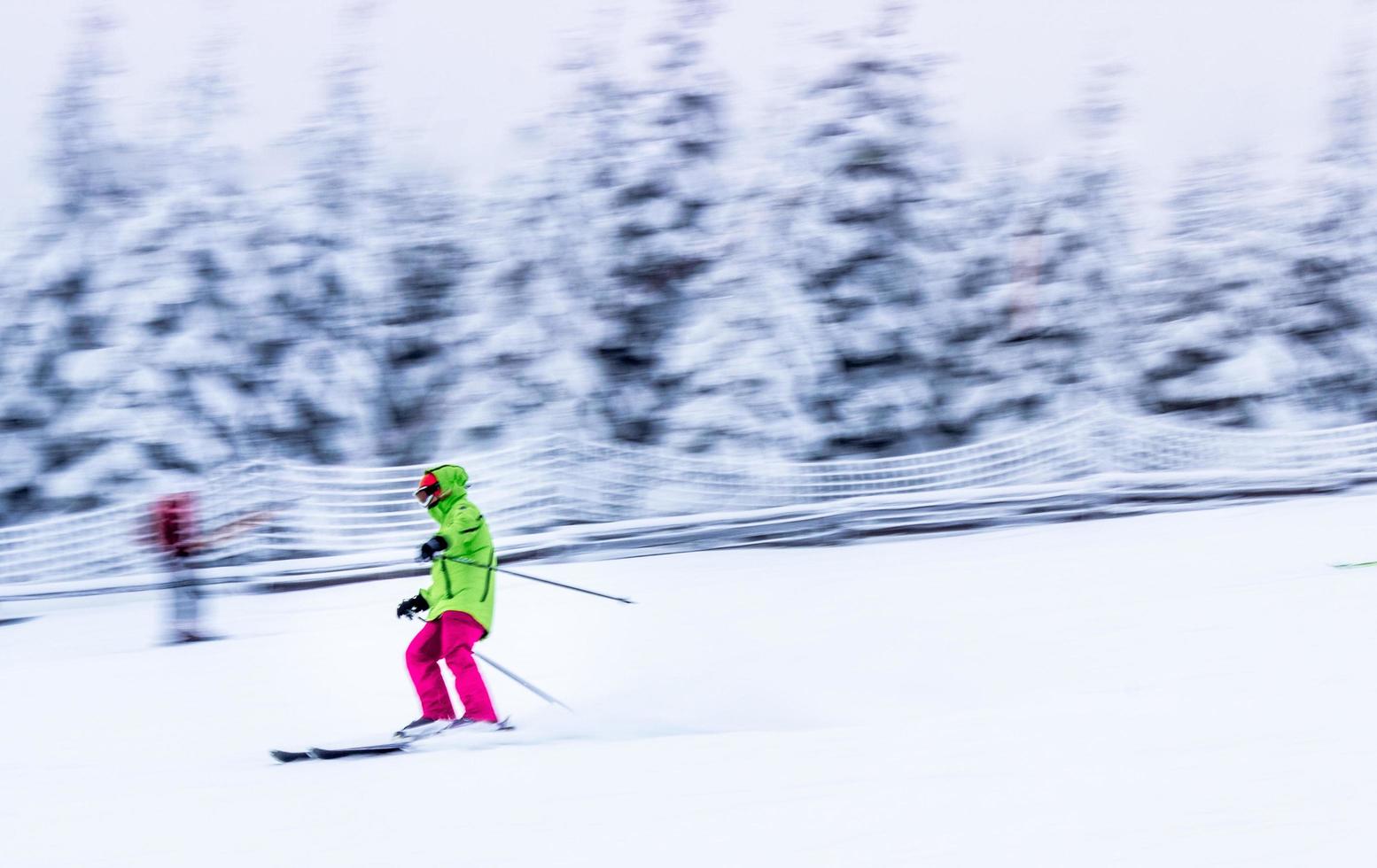 fotografia de foco seletivo de pessoa nas lâminas de esqui na pista de esqui foto