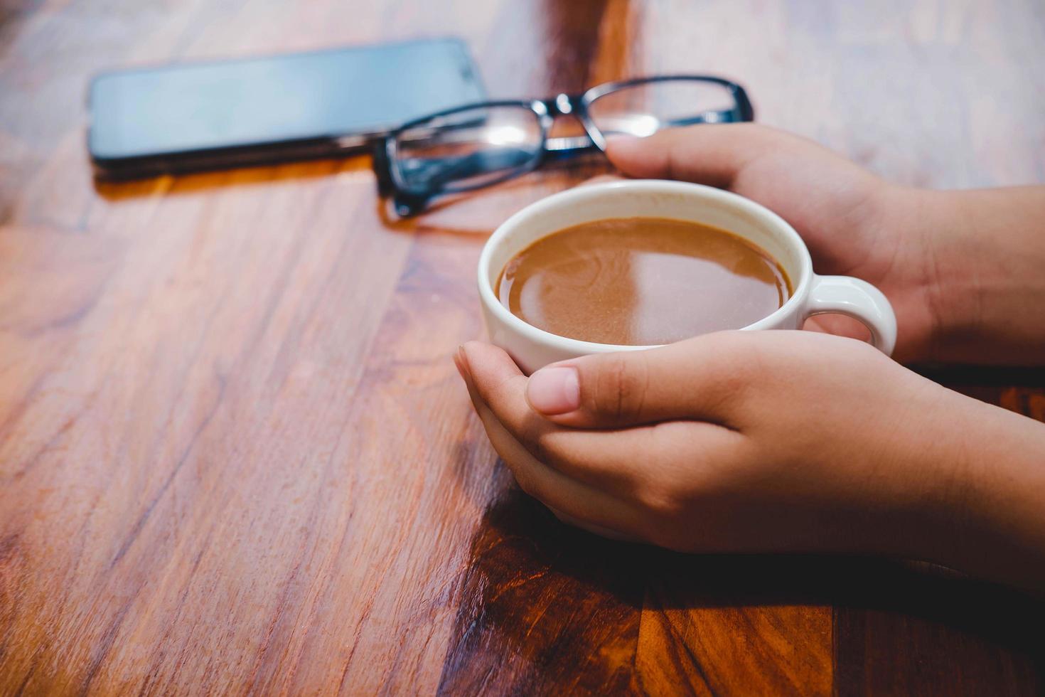 uma xícara de café em uma mesa de madeira em uma cafeteria foto