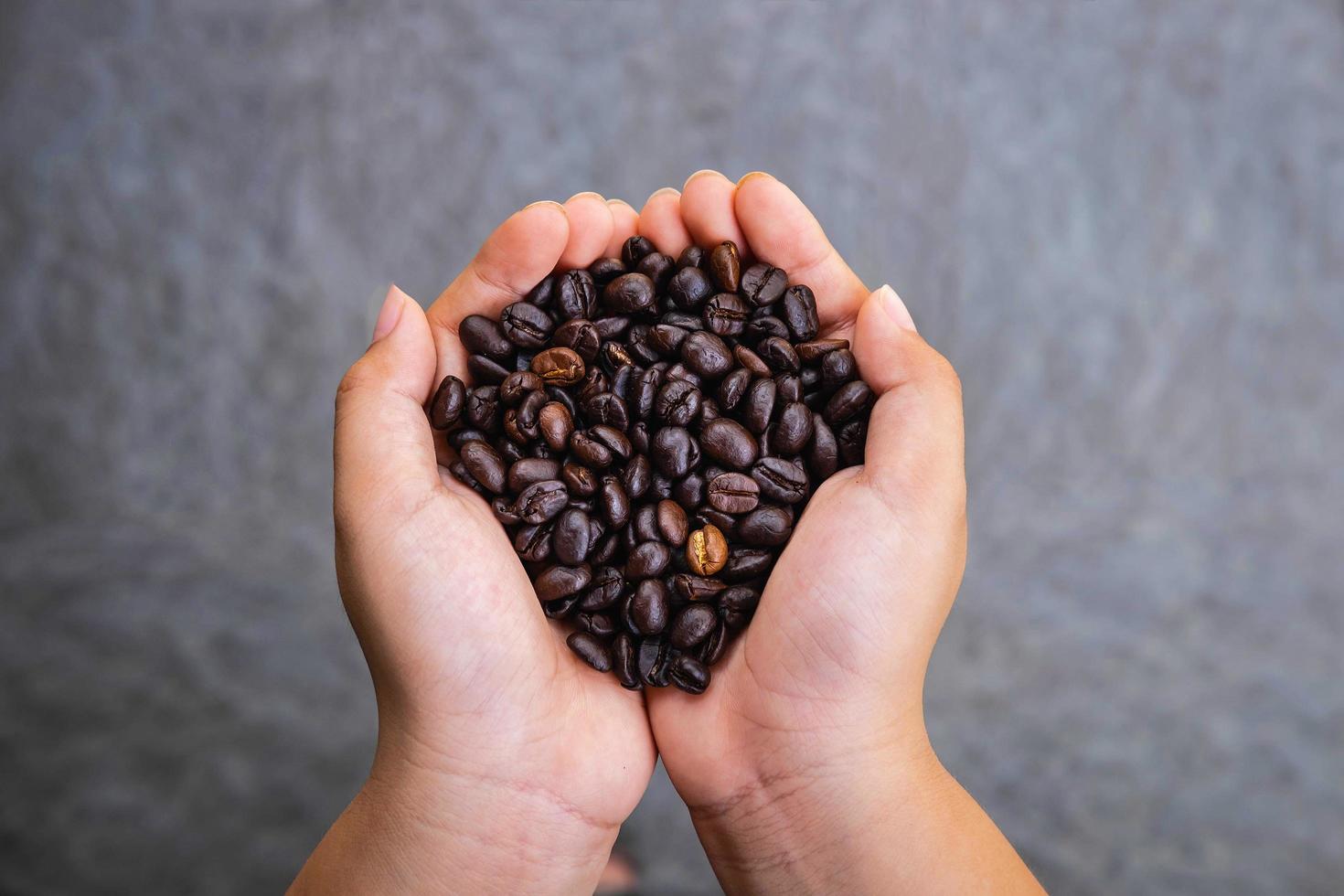 grãos de café torrados na mão foto