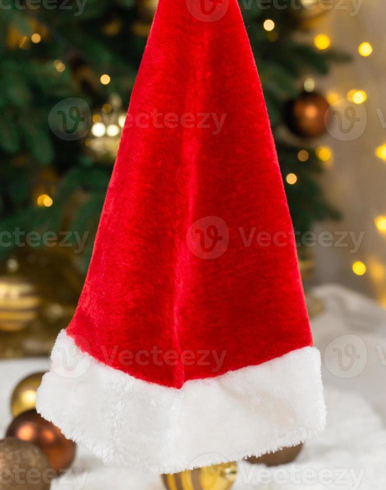 chapéu de papai noel no fundo de uma árvore de natal e guirlandas foto