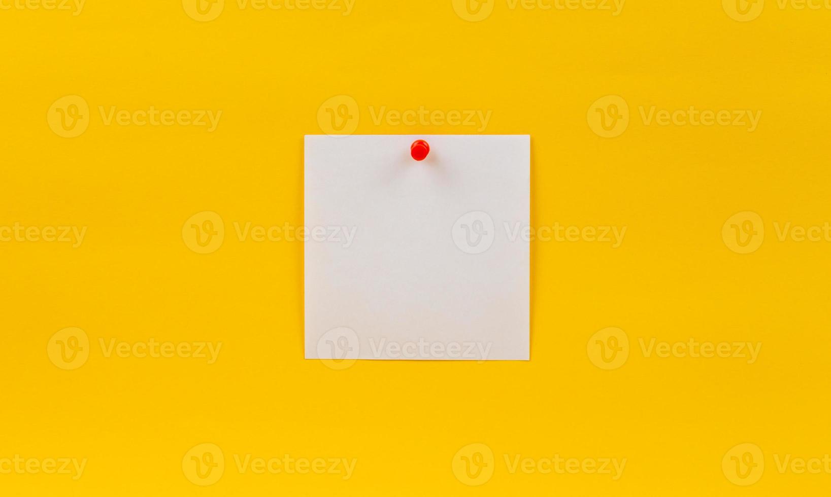 nota de papel em branco vazia fixada em alfinete vermelho em um fundo amarelo foto