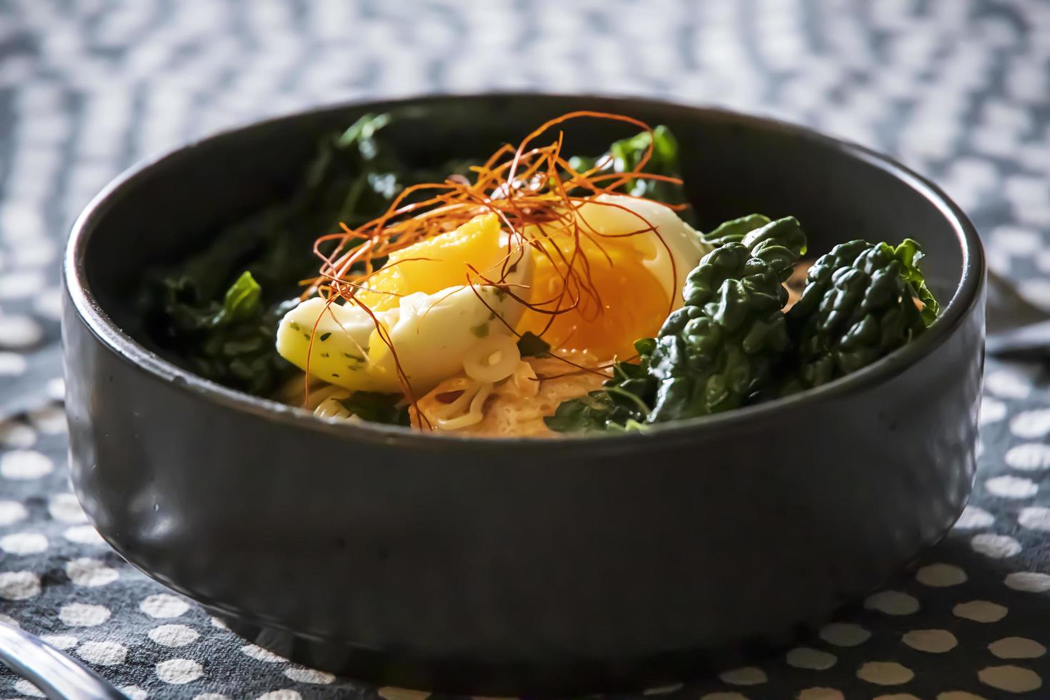 ovo em cima de macarrão de couve e ramen foto