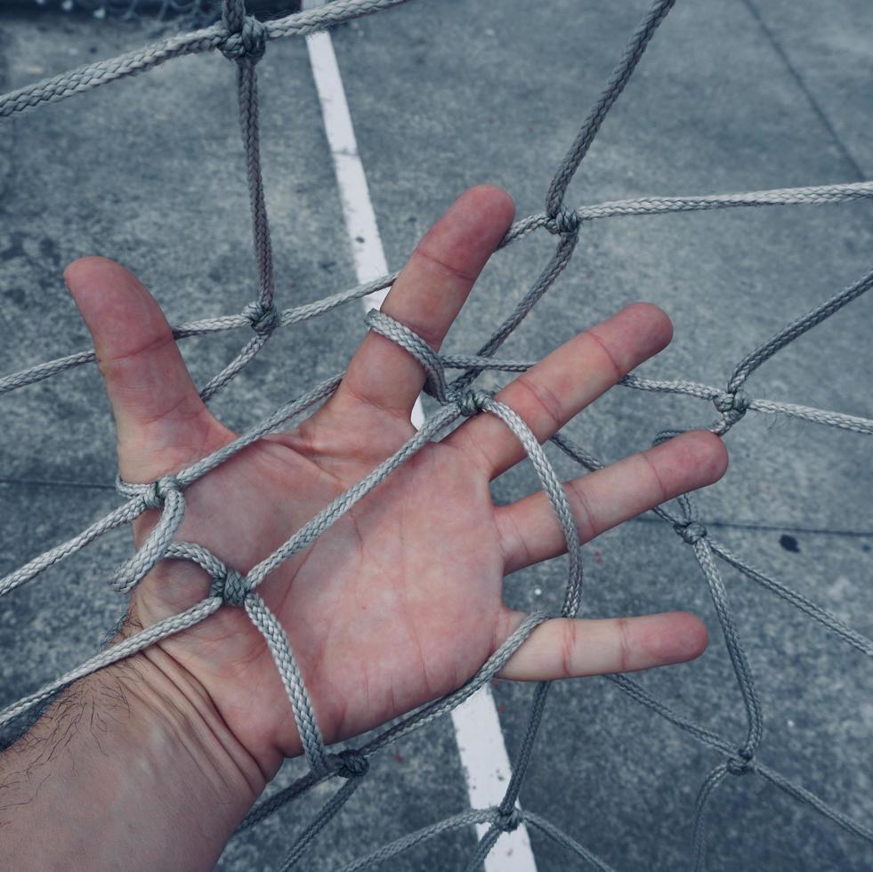 mão tocando uma rede de corda foto