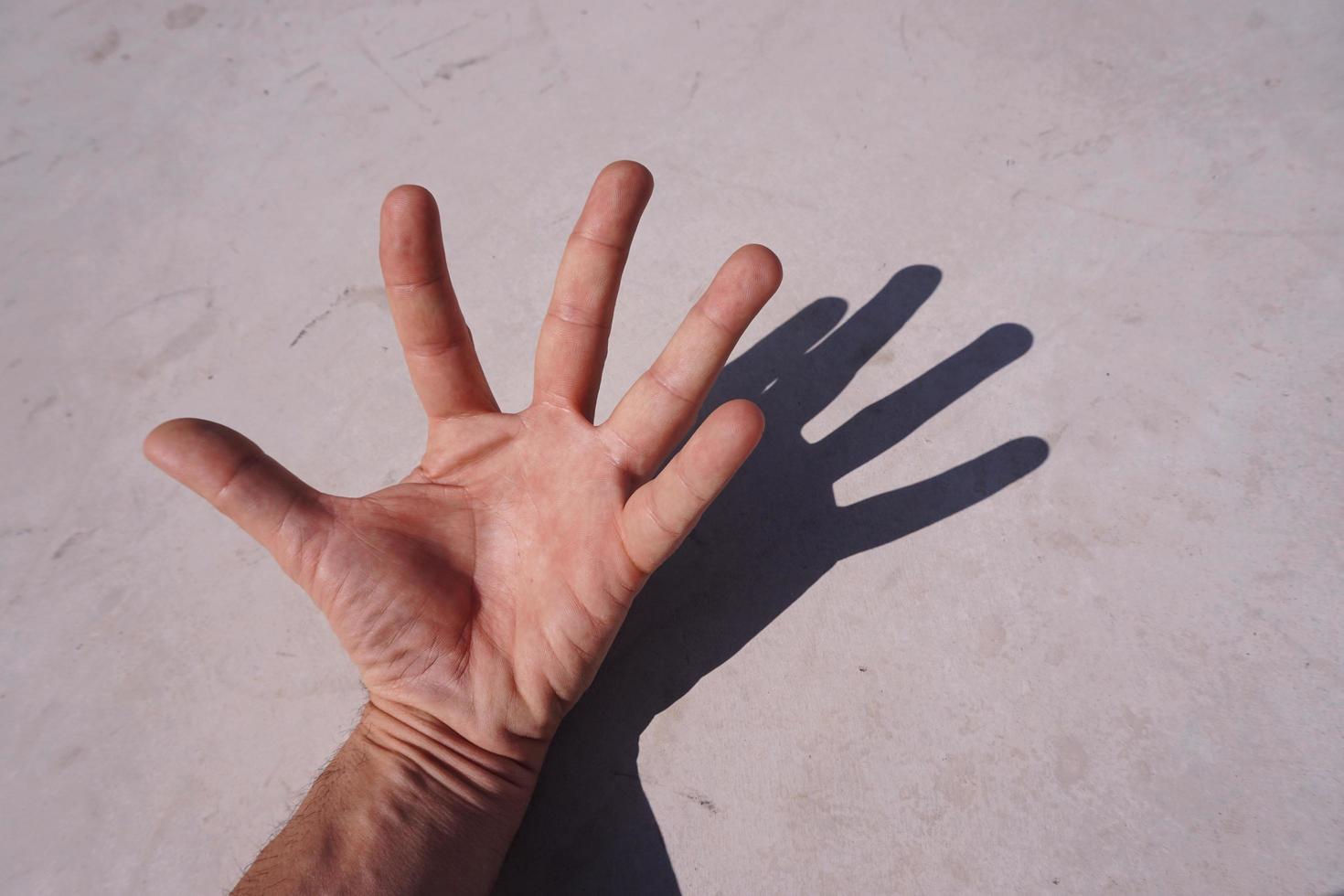 mão gesticulando nas sombras foto