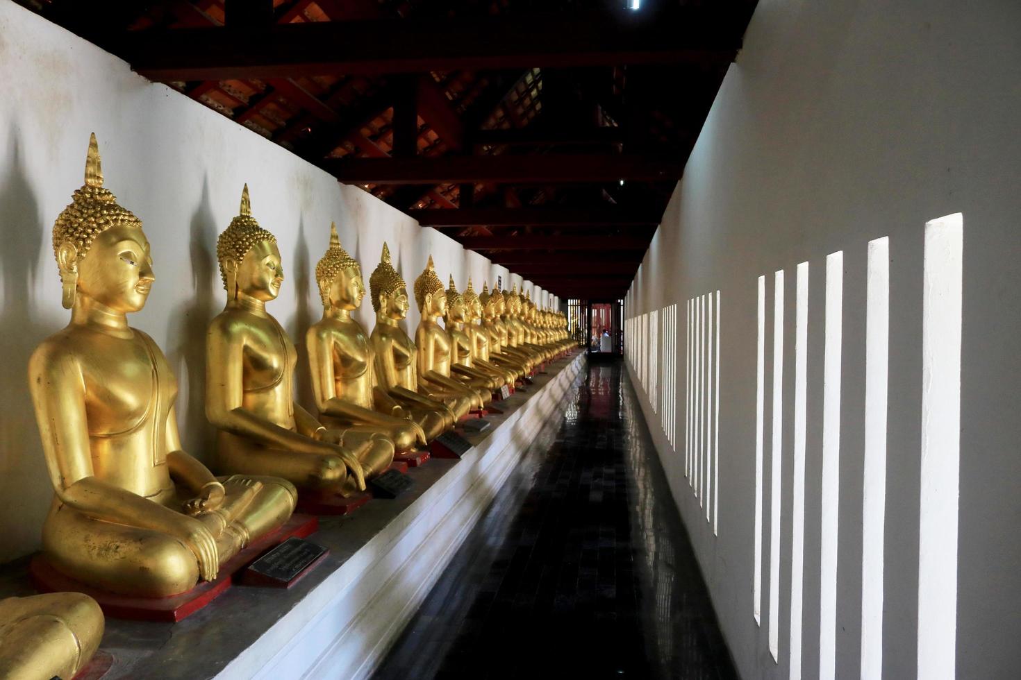 cidade, país, mm dd, aaaa - estátuas de ouro de Buda no templo foto