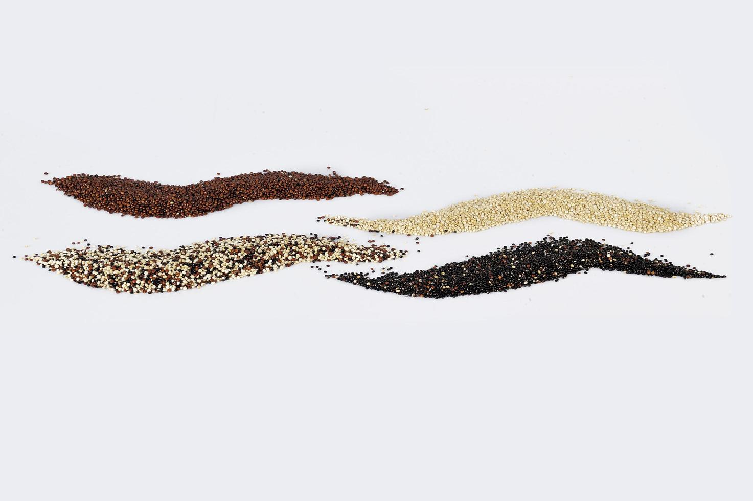 grãos de quinua preta vermelha e branca isolados no fundo branco foto