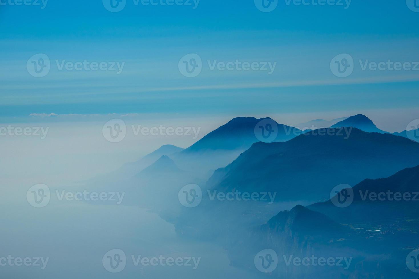céu azul e neblina nas montanhas ao redor do lago Garda foto