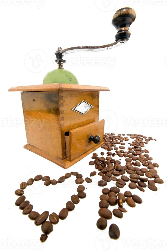 moedor de café com grãos de café isolados no branco foto