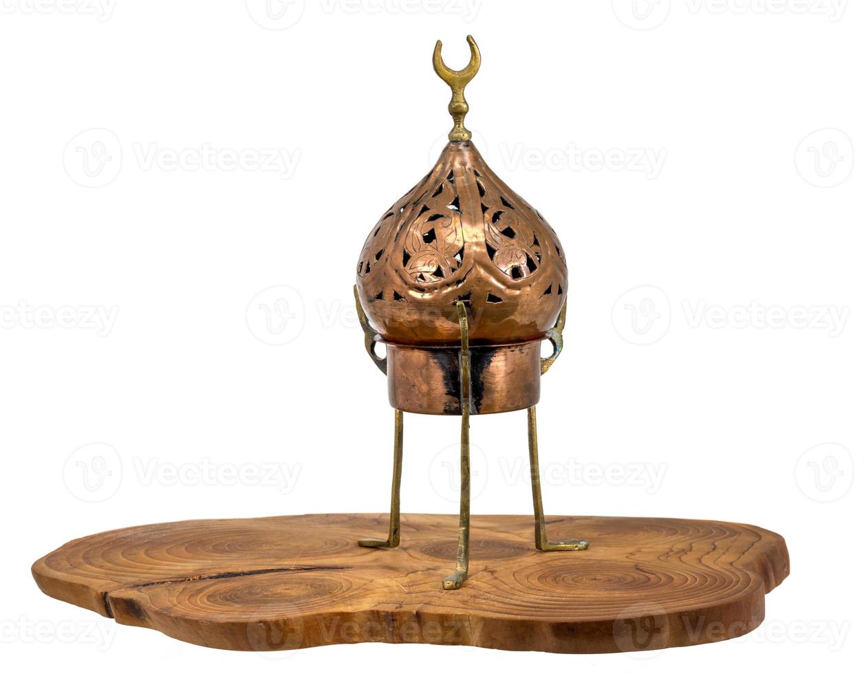 antigo queimador de incenso oriental feito de cobre em um disco de madeira foto