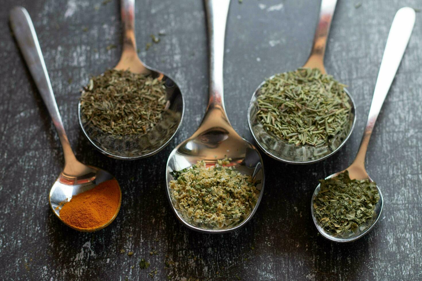 colheres com especiarias e ervas em uma Preto fundo. Comida e cozinha ingredientes. foto