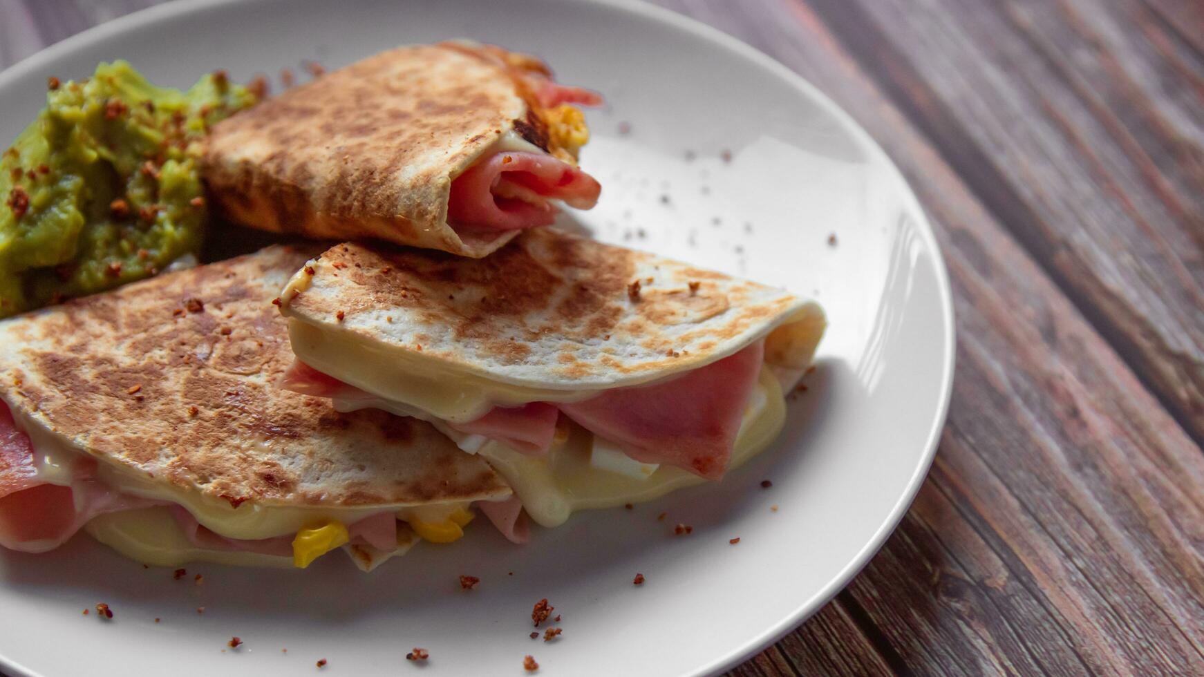 uma prato do Comida com uma Quesadilla e guacamole em isto. foto