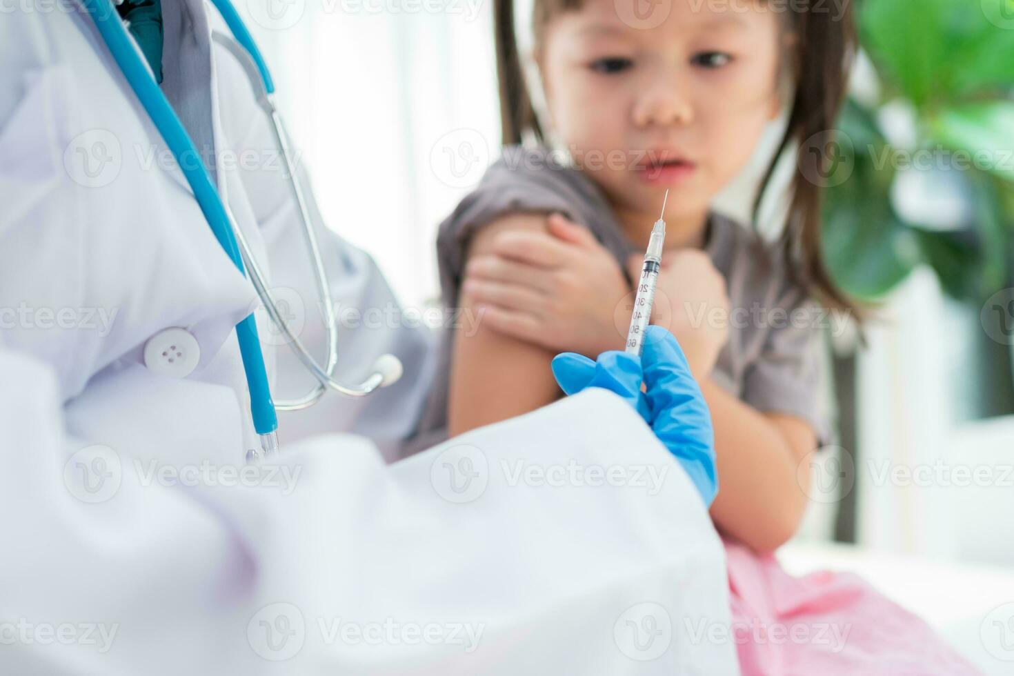 médico segurando seringa para preparar vacinado dentro a ombro do ásia menina crianças dentro a hospital. pediatra faz vacinação para crianças. vacinação, imunização, doença prevenção conceito. foto