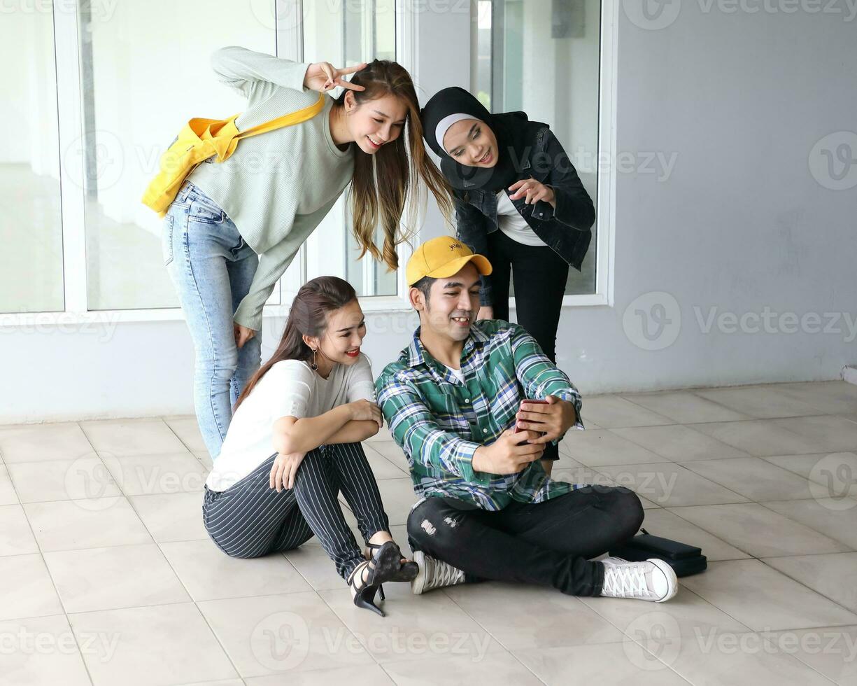 jovem ásia malaio chinês homem mulher interior escada corredor campus livro Arquivo pasta computador portátil computador telefone sentar ficar de pé estude misturar-se foto