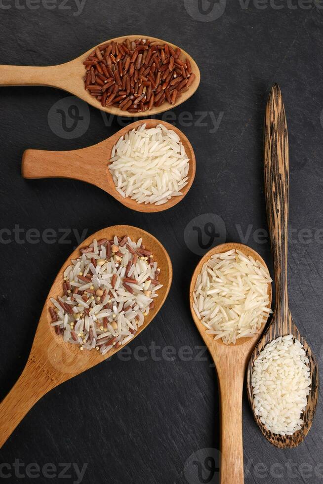 grandes grão basmati médio grão jasmim curto grão Arroz a grega polau risoto Castanho baixo glicêmico índice gi arroz dentro de madeira colher em Preto fundo cópia de texto espaço topo plano deitar Visão foto