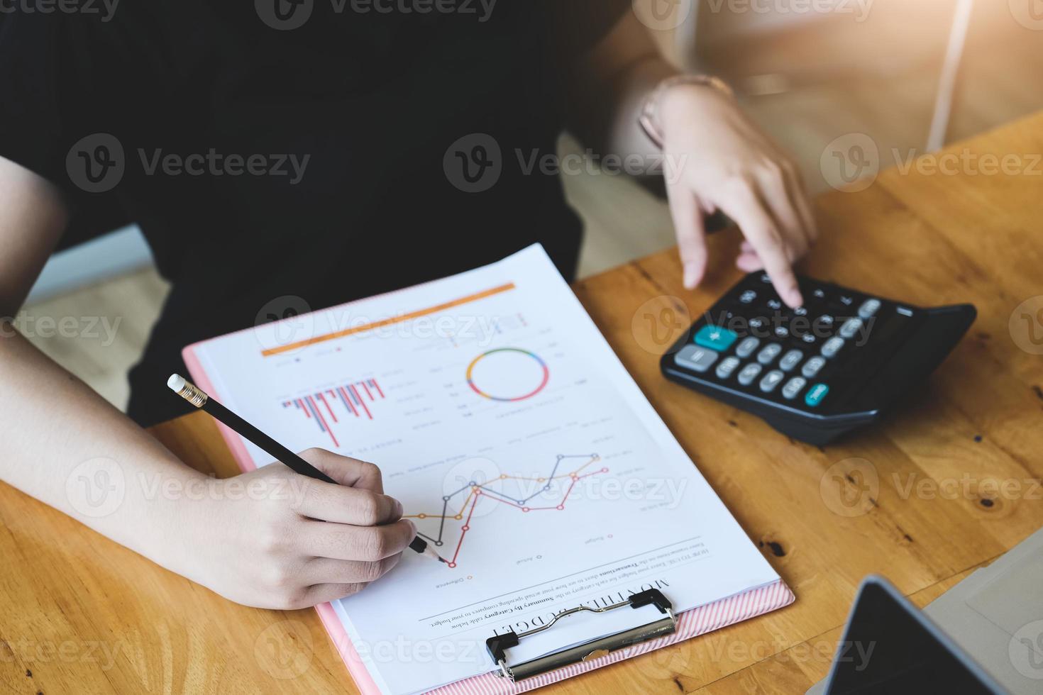 mulher de negócios usando calculadora para revisar o balanço patrimonial foto