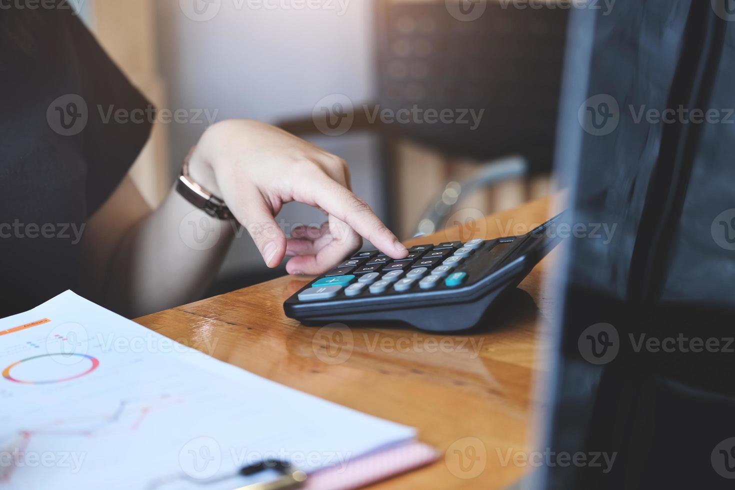 mulher de negócios usando calculadora para revisar o balanço patrimonial foto
