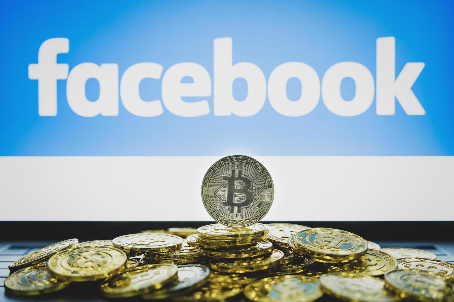 chiang mai, tailândia, 19 de junho de 2019, logotipo do Facebook na tela e moedas bitcoin foto