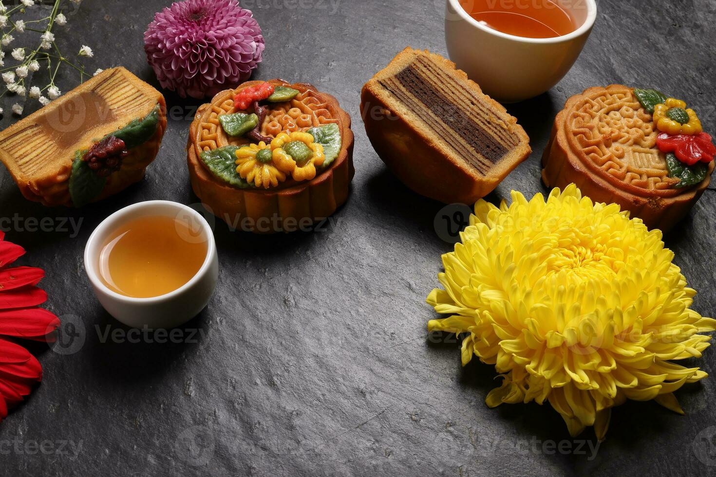 colorida flor decorado mooncake chinês meio outono festival Preto ardósia pedra fundo branco xícara de chá vidro chaleira margarida crisântemo mãe rosa bebê respiração flor vermelho amarelo Rosa roxa tolet foto