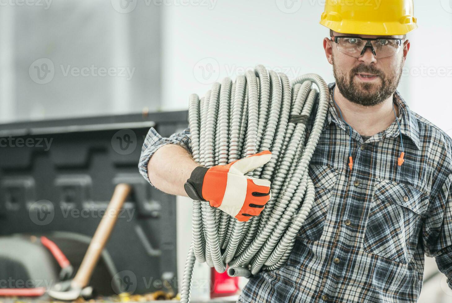 profissional contratante com conduta elétrico tubo em dele ombro foto