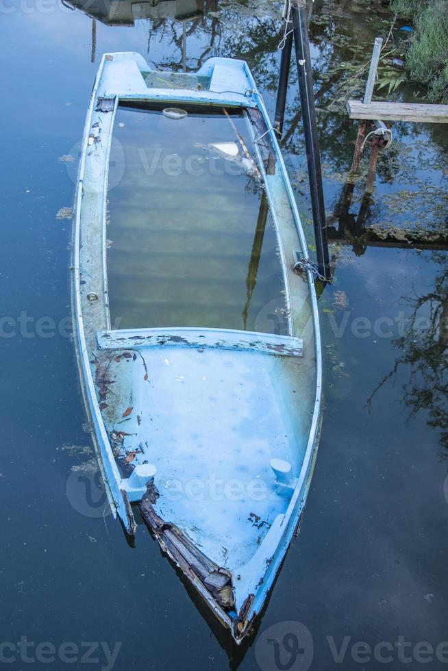 barco de pesca de madeira abandonado e quase afundado foto