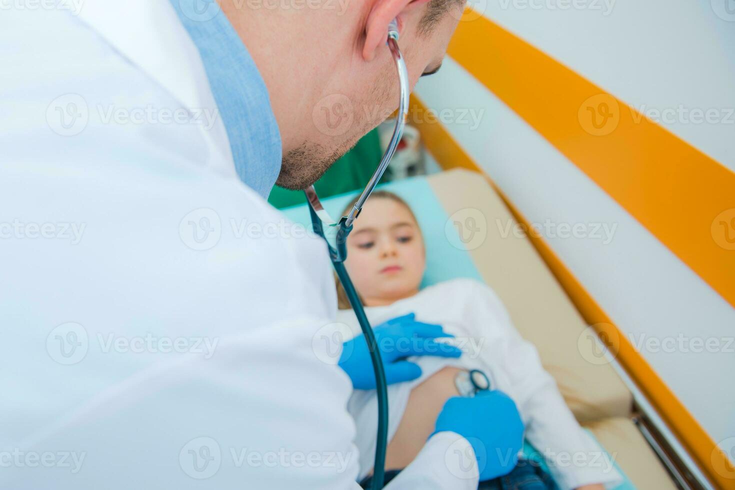 médico examinando dele pequeno paciente em hospital cama. foto
