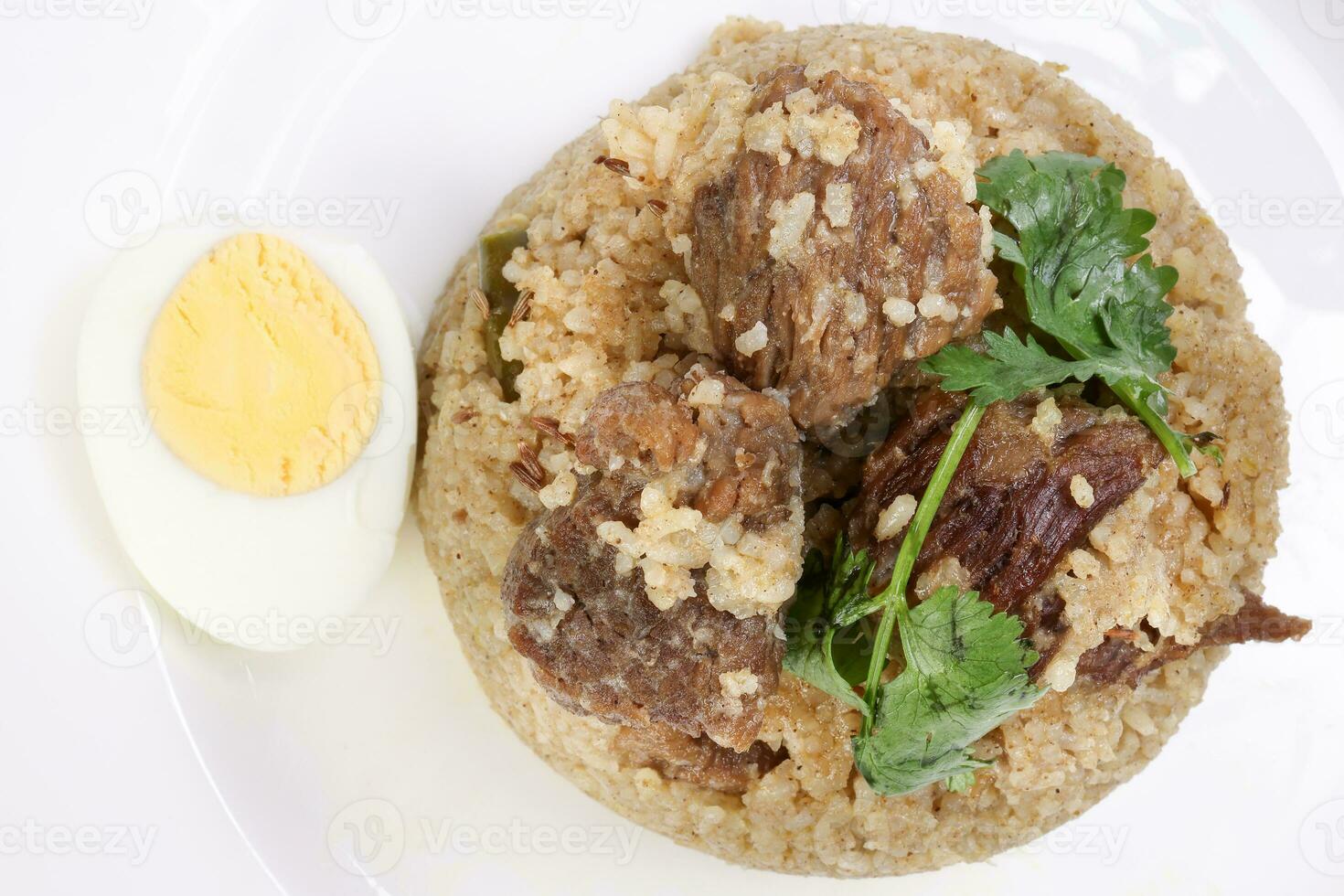 carne Biryani Tehari cozinhou dentro reunido óleo com fervido ovo coentro folha guarnição, enfeite, adorno em branco prato sobre branco fundo foto
