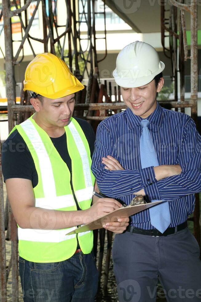 sul leste ásia jovem malaio chinês homem mulher vestindo em segurança capacete construção local trabalhos foto