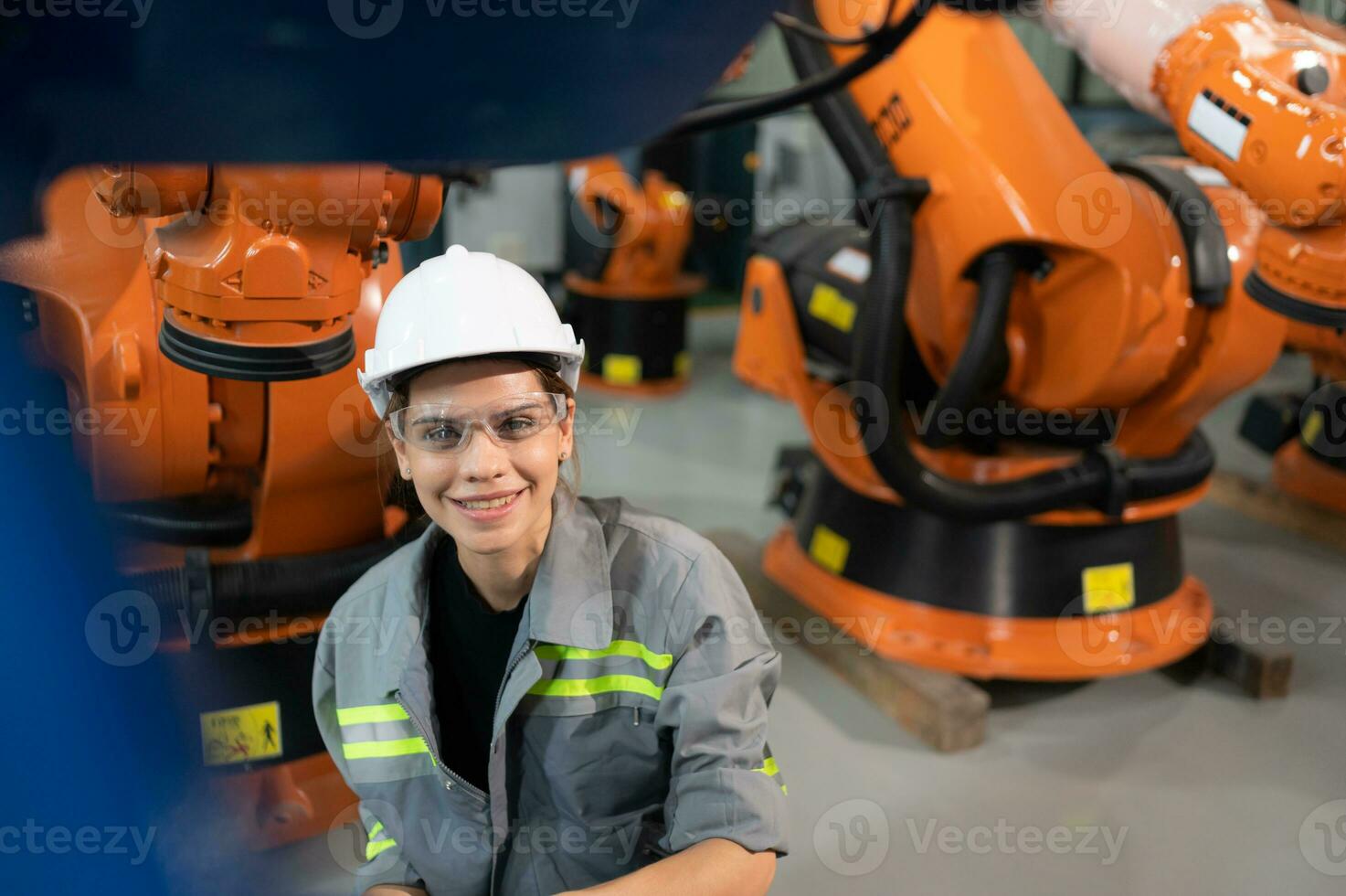 uma fêmea engenheiro instala uma programa em uma robótica braço dentro uma robô armazém. e teste a Operação antes enviando a máquina para a cliente. foto