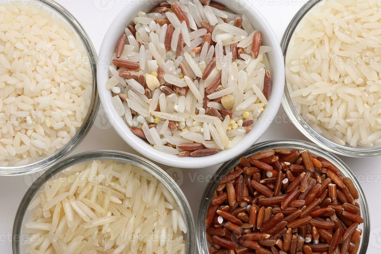 grandes grão basmati médio grão jasmim curto grão Arroz a grega polau risoto Castanho baixo glicêmico índice gi arroz dentro pequeno vidro tigela em branco fundo cópia de texto espaço topo plano deitar Visão foto