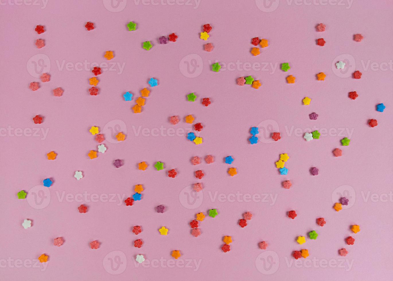 flores coloridas de confete doce em fundo rosa foto