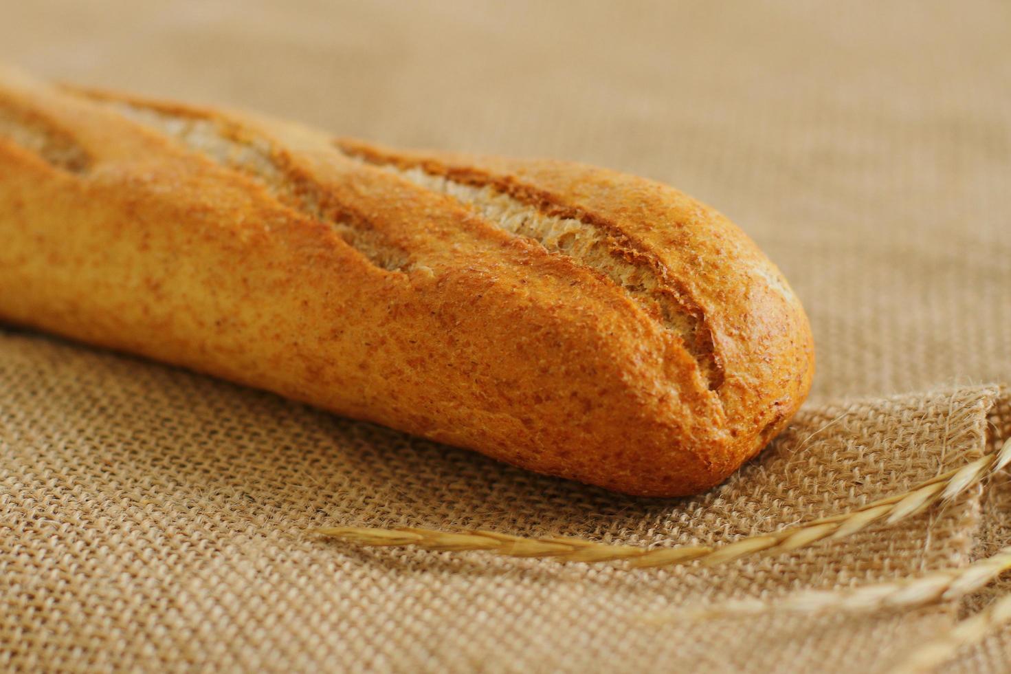 baguete francesa em pano de saco pão fresco em serapilheira foto