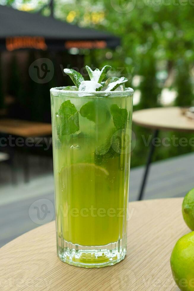 Mojito e limas em uma rua cafeteria mesa contra vegetação foto