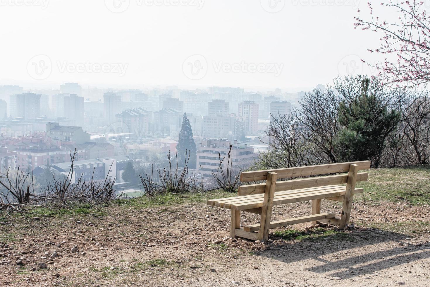 banco de madeira vazio no parque da primavera sobre a cidade foto