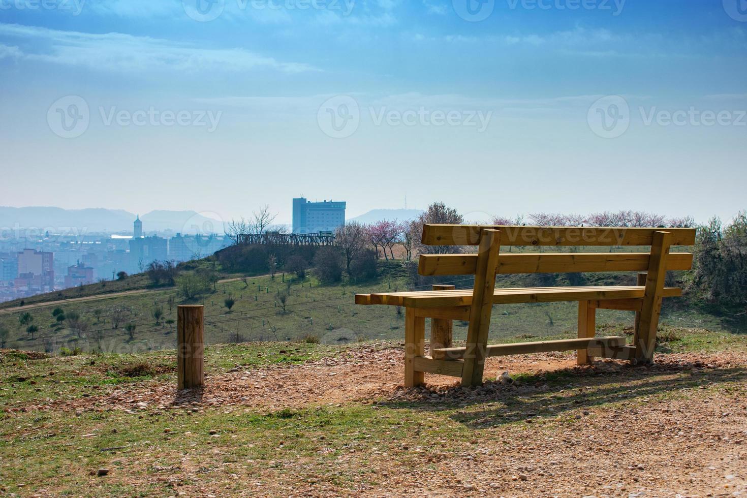 banco de madeira vazio no parque da primavera sobre a cidade foto