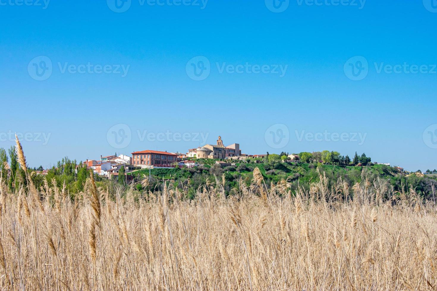 vista distante da vila castelhana sobre prados semeados foto