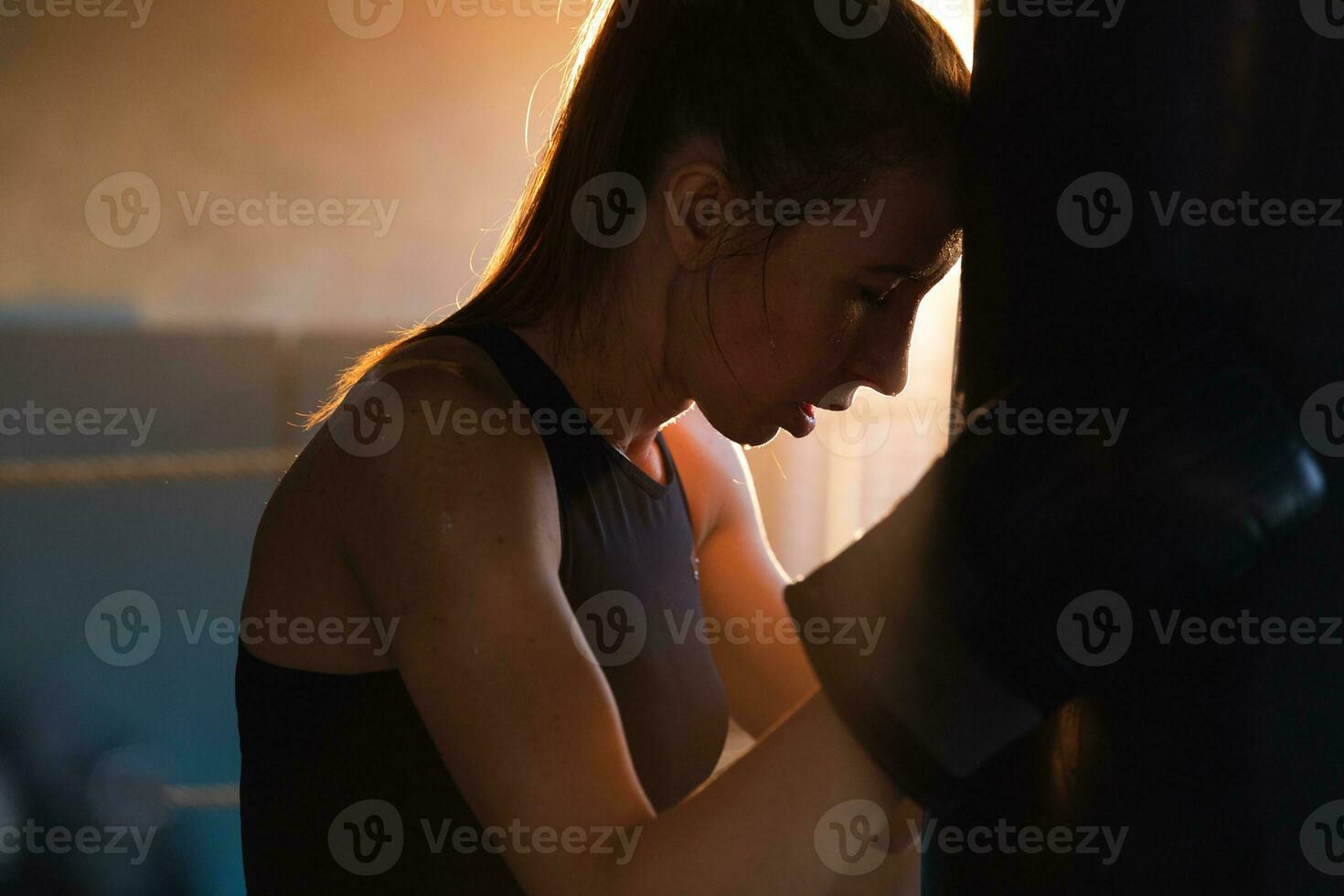 mulheres auto defesa menina poder. Forte mulher lutador em repouso depois de luta Treinamento em boxe anel. Forte menina cansado depois de soco boxe bolsa. Treinamento dia dentro academia. força em forma corpo exercite-se treinamento. foto