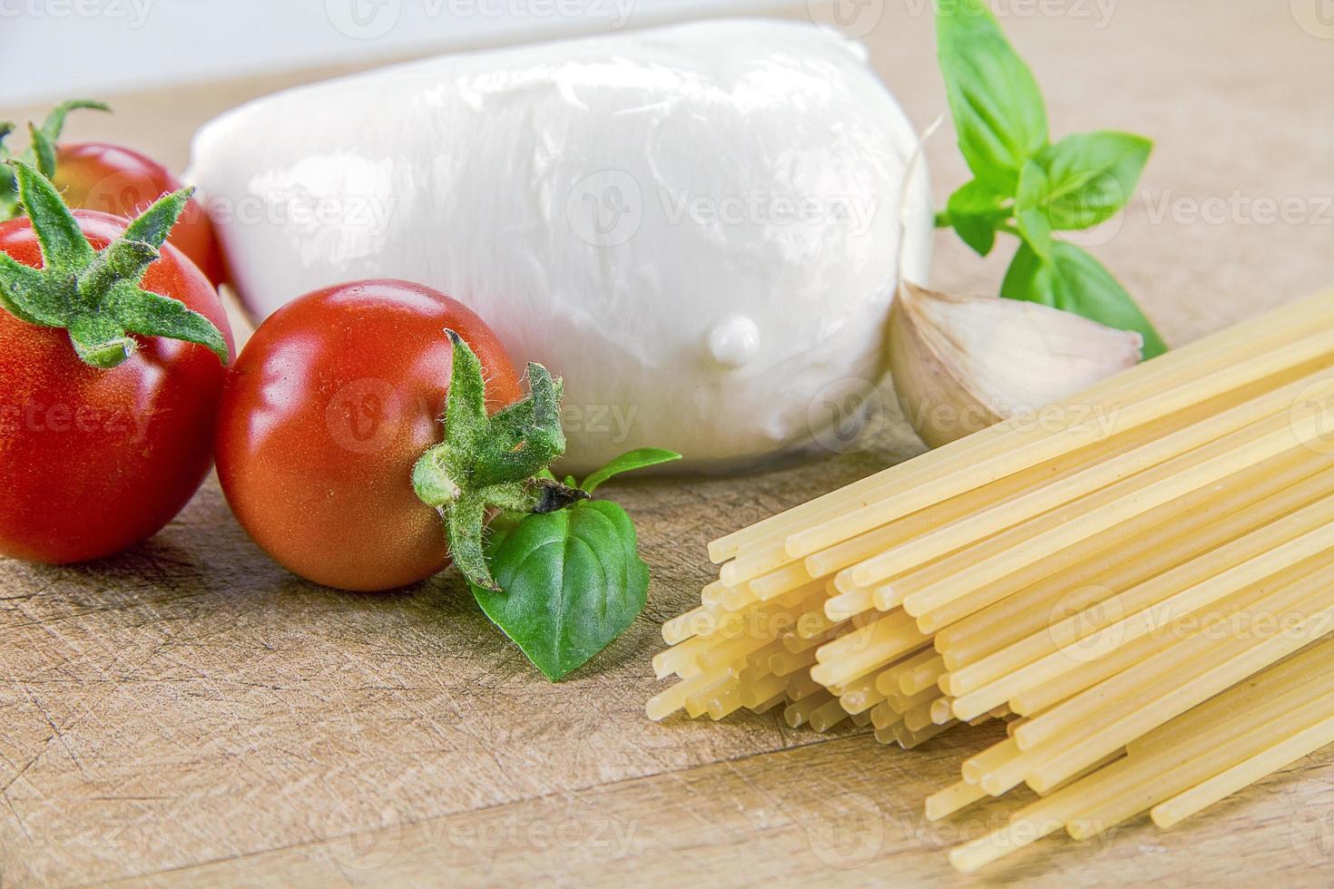 mussarela orgânica italiana com tomate cereja e manjericão em uma tábua foto