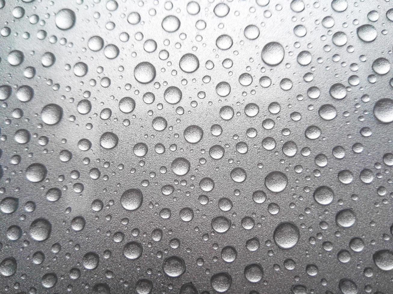 gota de orvalho da chuva em um fundo de cor cinza foto