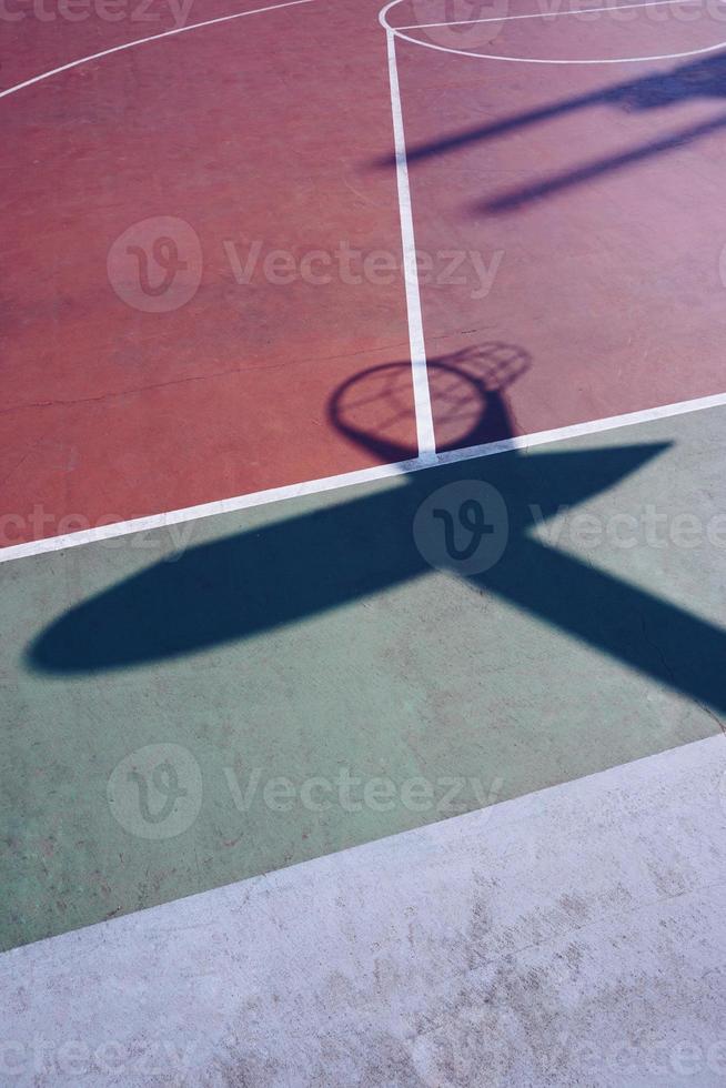 sombras de aro na quadra de basquete de rua foto